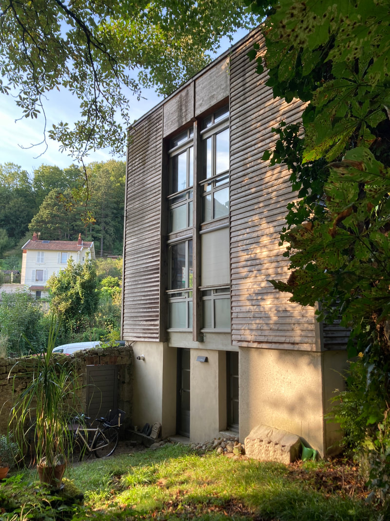 Façade en bois de l'agence, côté jardin, en fin de journée