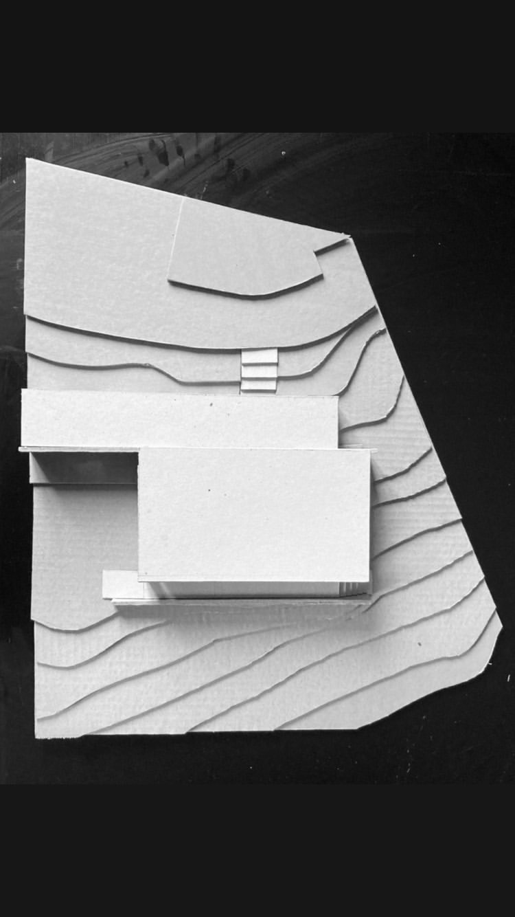 Maquette d'étude blanche posée sur un terrain en courbes de niveau