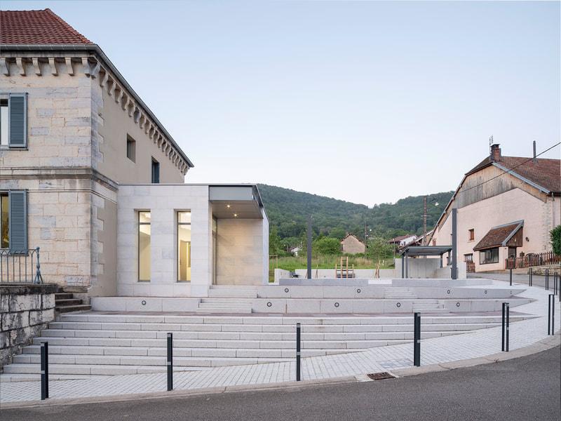 Extension de la mairie de Hyèvre-Paroisse : pavillon monolithe en pierre calcaire accolé au bâtiment traditionnel, nouveau parvis