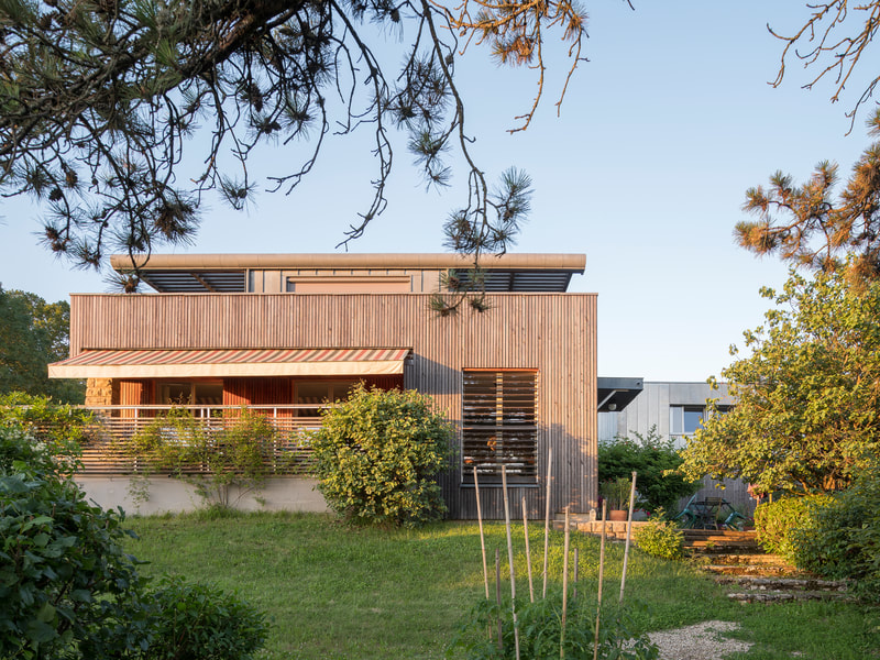 Maison Bettinger à Besançon : pavillon des années 1960 rénové, bardage bois et zinc, terrasse abritée par des brise-soleil
