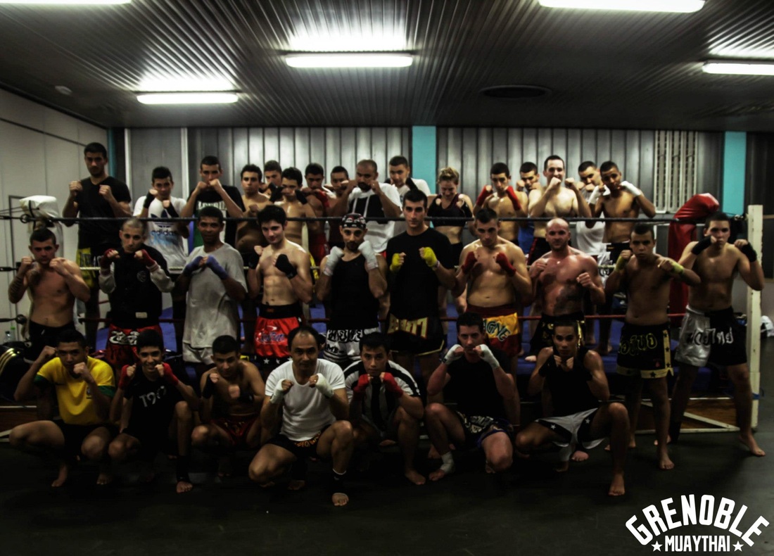Photo de groupe des adhérents du Grenoble Muaythai réunis dans la salle d'entraînement
