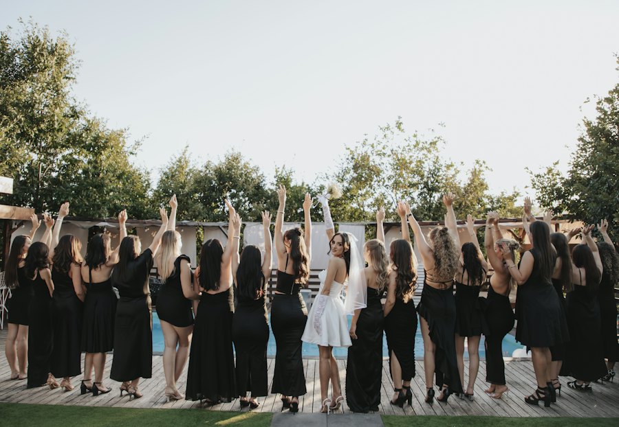 Future mariée entourée de ses amies, bras levés, célébrant son enterrement de vie de jeune fille