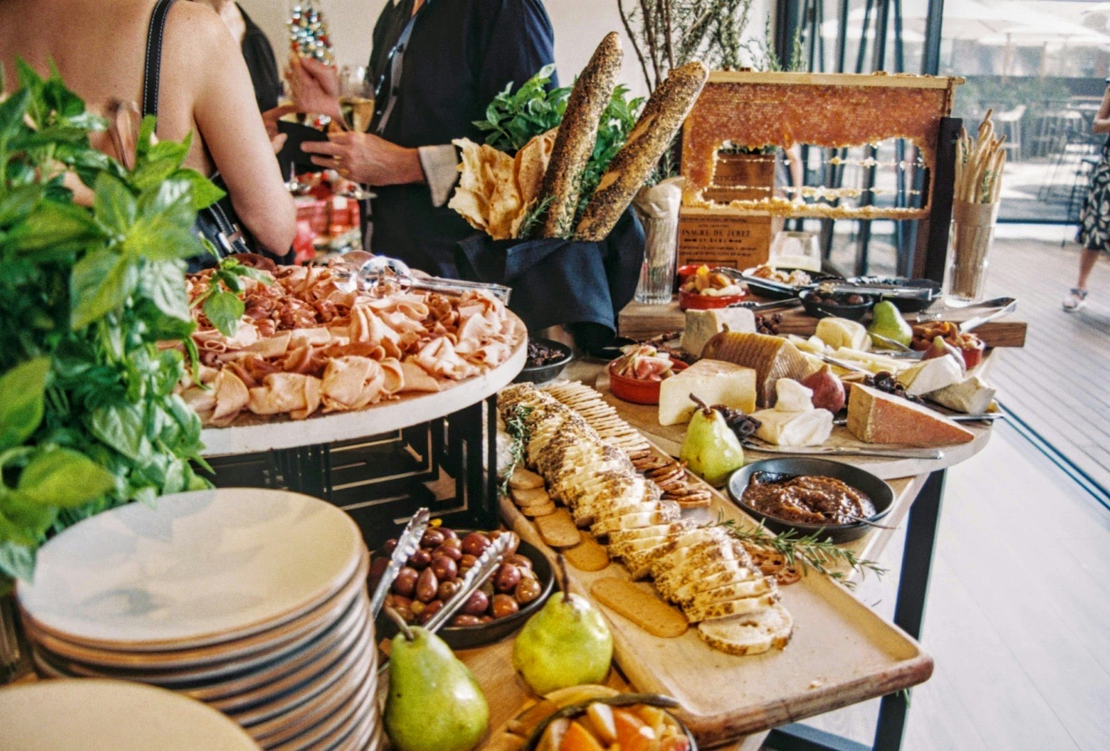 Buffet traiteur dressé pour une réception : planches de charcuterie, fromages, pains et fruits frais