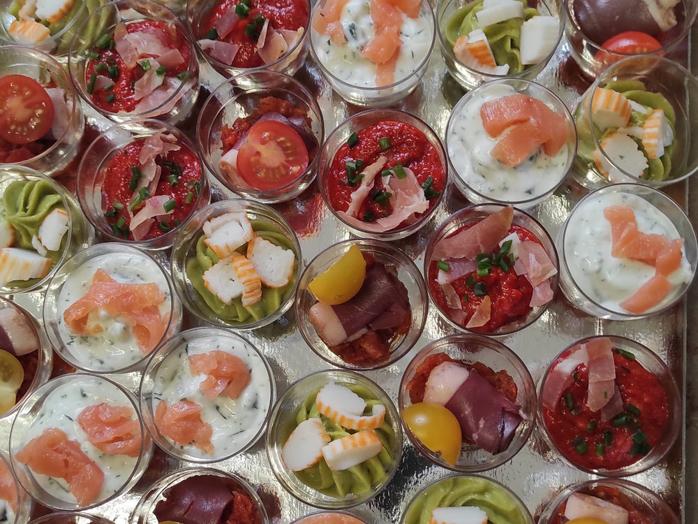 Verrines assorties saumon, tomate et légumes préparées pour un vin d'honneur