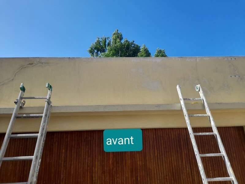 La façade du garage avant peinture, échelles en place et dessous de toit défraîchi