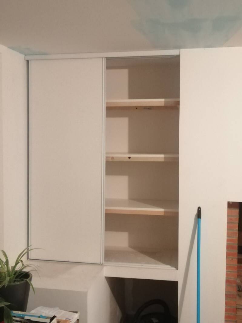 Portes de placard et étagères posées dans une niche murale