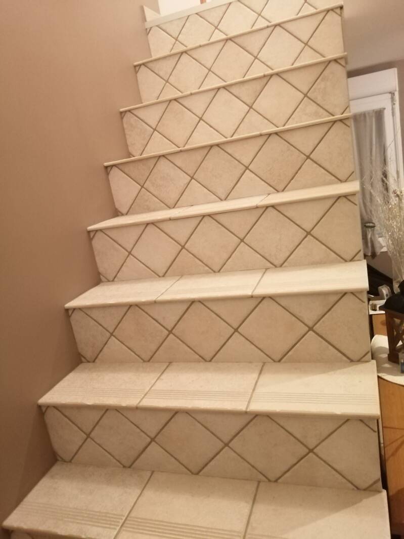Sol rénové avec pose de carreaux de ciment dans un escalier et un couloir
