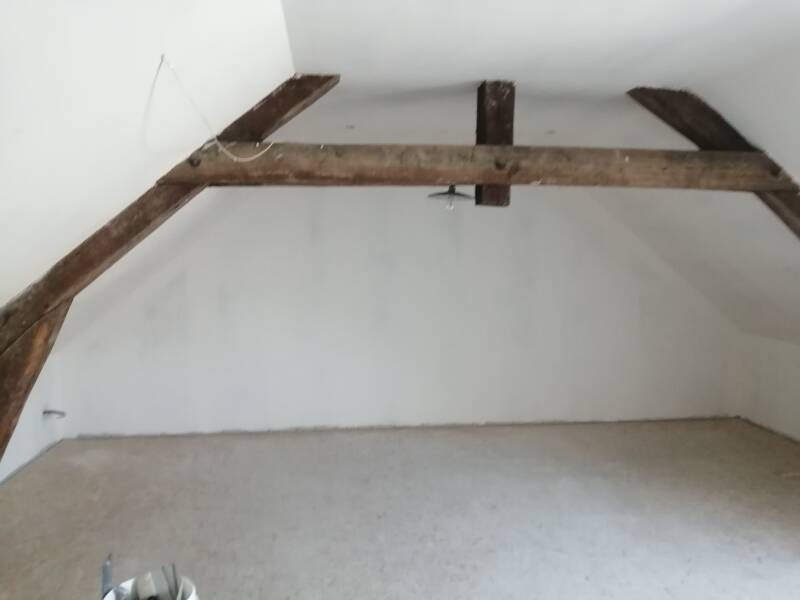 Combles aménagés avec murs et plafond enduits, prêts à peindre