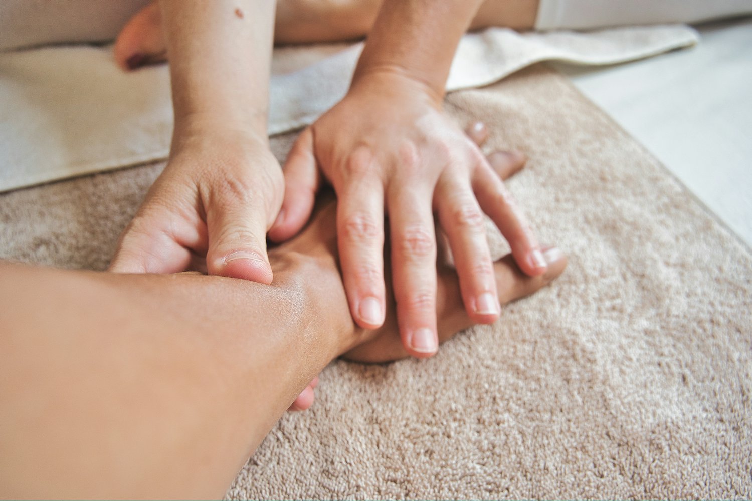 Massage des mains reçu sur une serviette douce, lors d'une prestation de groupe.