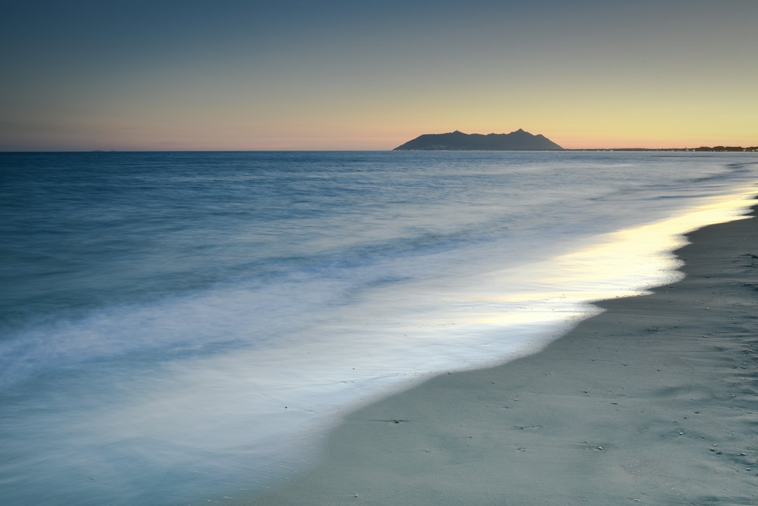 Vagues venant mourir sur le sable d'une plage méditerranéenne à la lumière du soir.