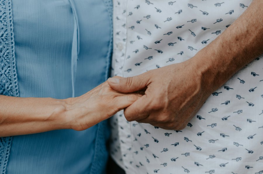 Les mains d'une aidante tiennent délicatement celles d'une personne âgée