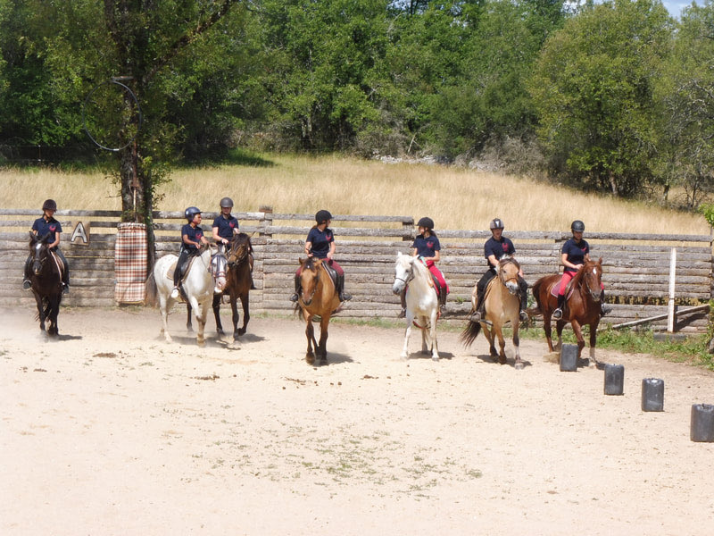Groupe de cavaliers rassemblés à cheval devant les bâtiments de la ferme du Mas de Laval