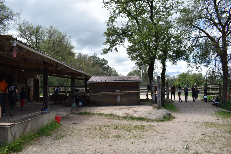 Vue de la carrière en sable et des abris de la ferme équestre