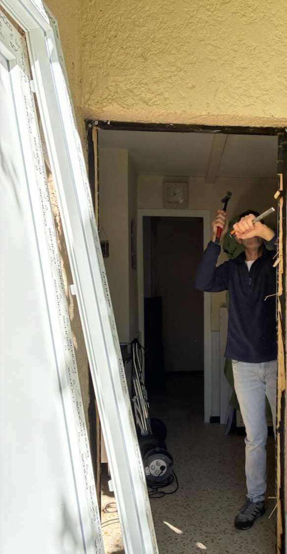 Ludovic Murcia, artisan menuisier, en train de déposer une ancienne menuiserie sur un chantier de rénovation