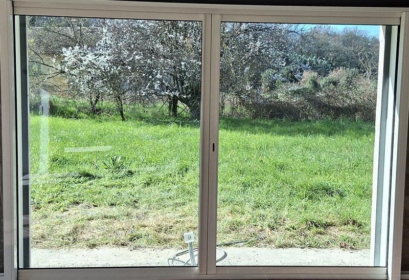 Baie vitrée coulissante en aluminium ouvrant sur un jardin à Saint-André-de-Sangonis