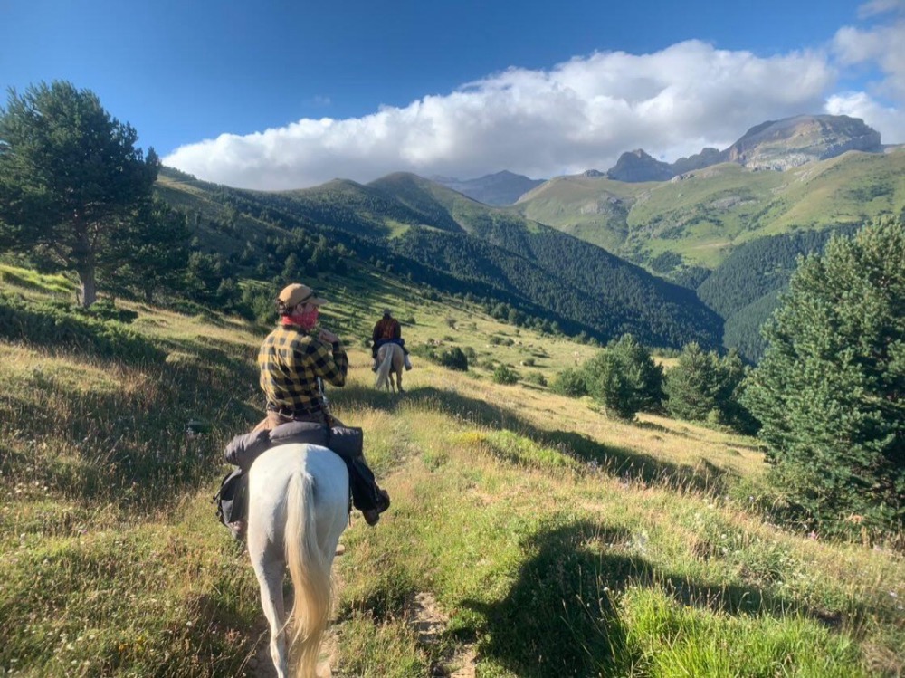 Cavaliers en randonnée sur un sentier de montagne face aux Pyrénées