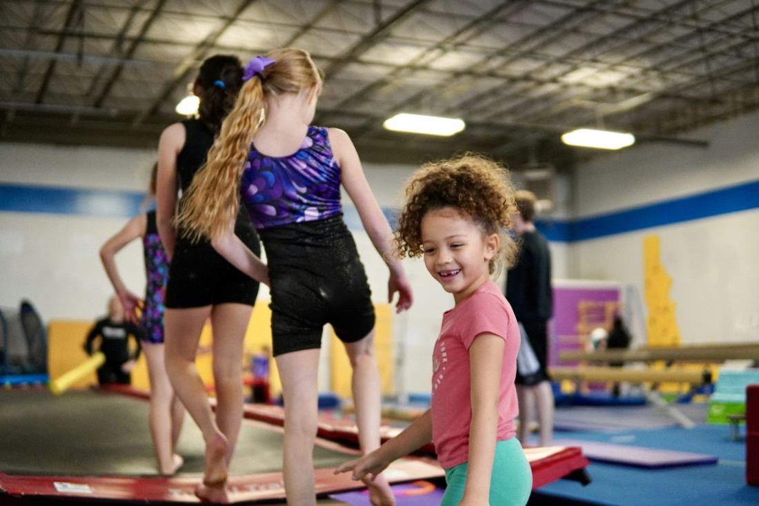 Groupe d'enfants souriants pendant un cours de gymnastique en salle